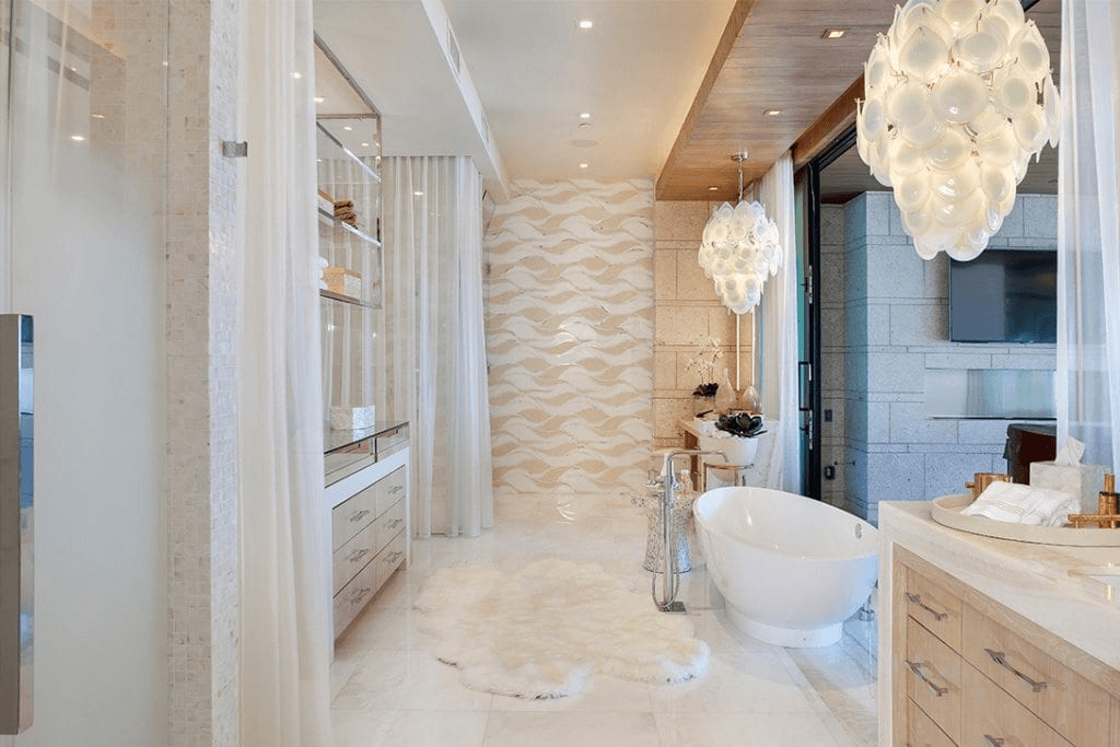 Light-filled Palm Beach luxury bathroom featuring wave tile, fur rug, and soaking tub