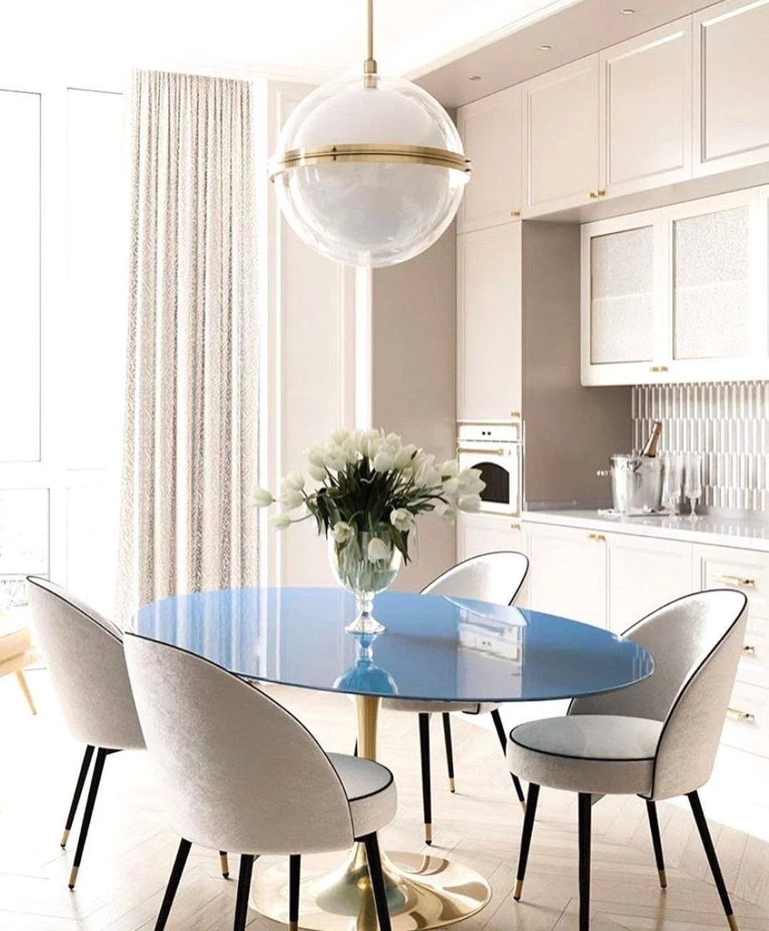 Palm Beach luxury interior design in a waterfront home shows a refined kitchen and eat in area with dramatic lighting and neutral colors.