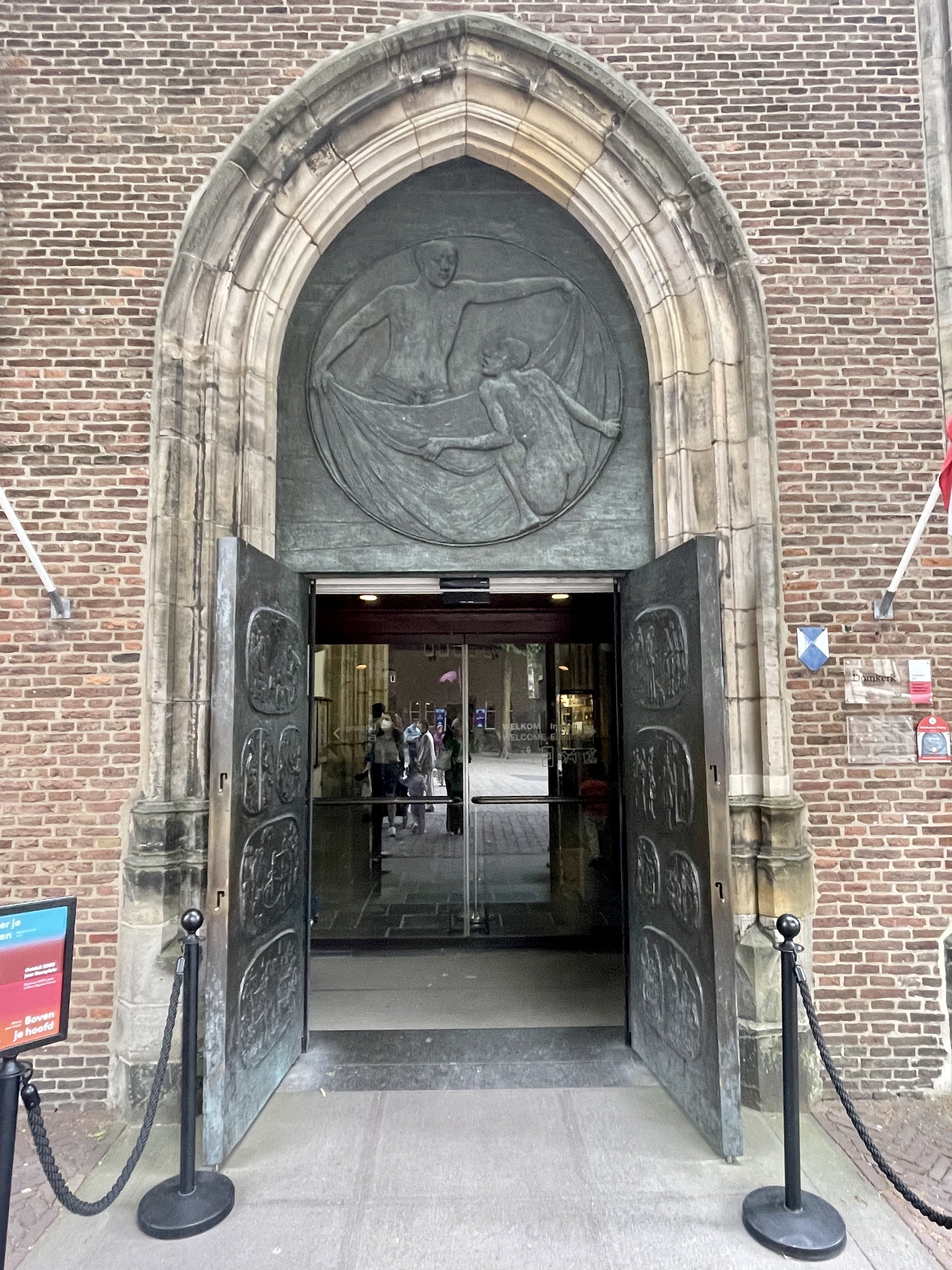 Utrecht Domkerk front doors opened under large bronze relief and pointed arch.
