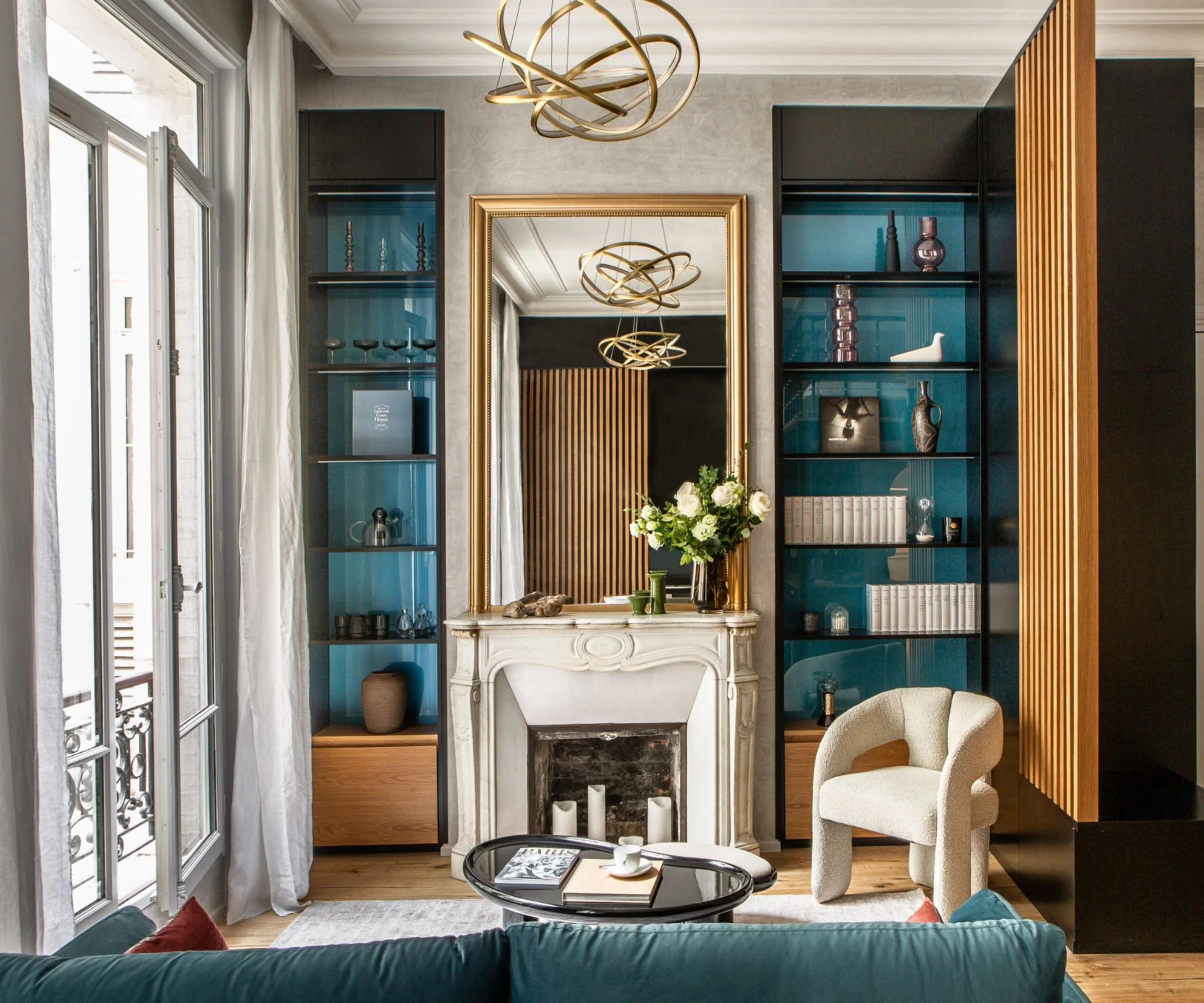 Refined Palm Beach living room with sculptural lighting and teal built-ins