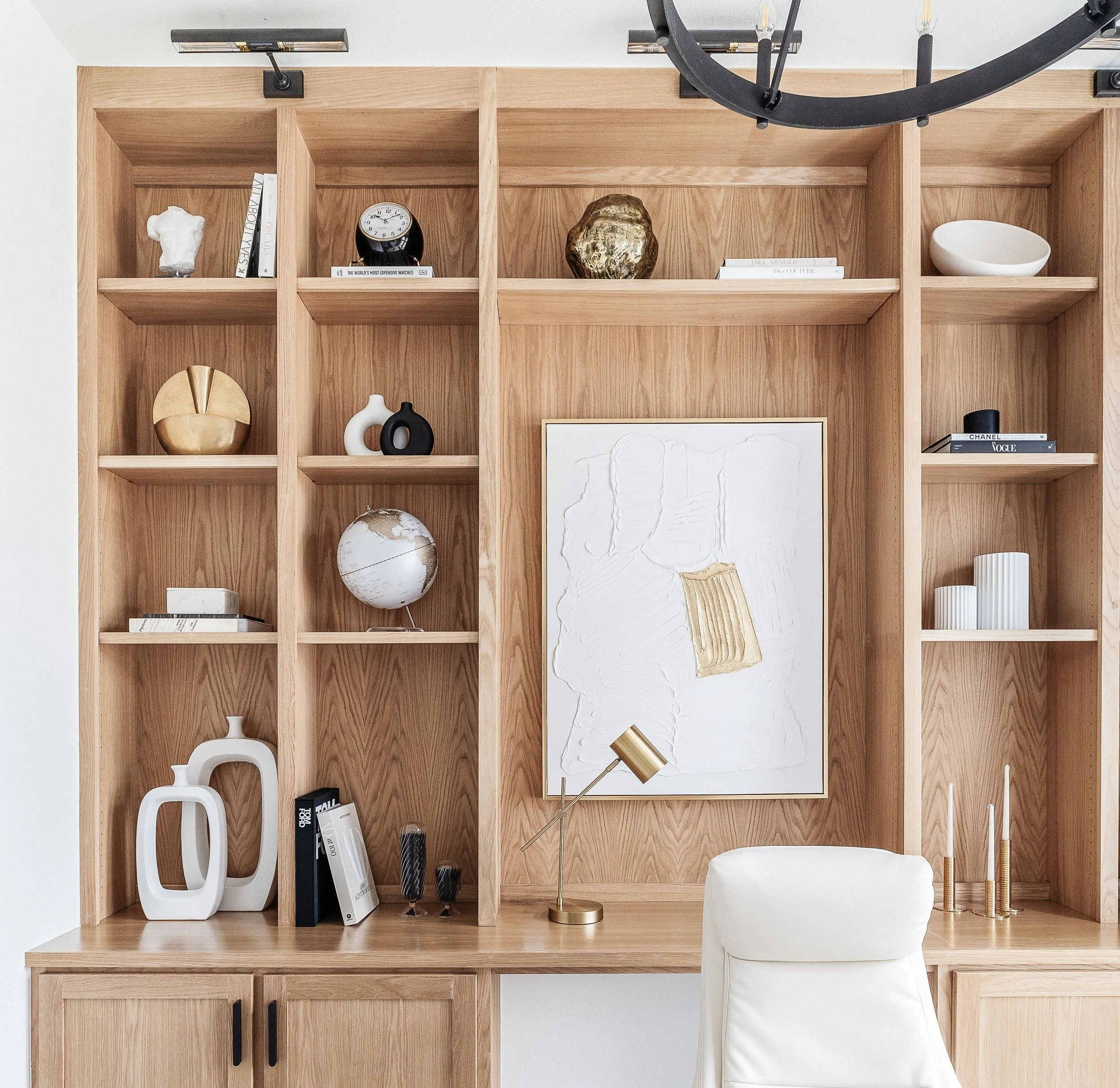 Built-in light wood office shelving styled with neutral decorative objects