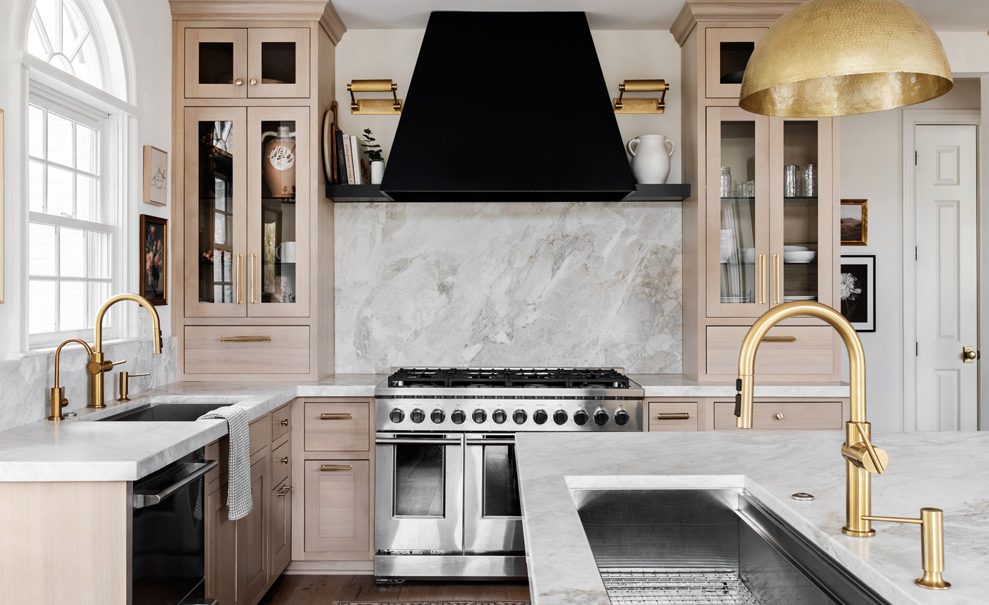 This oak kitchen has neutral porcelain countertops with an angular black hood. Brass plumbing and hardware adds gleam.