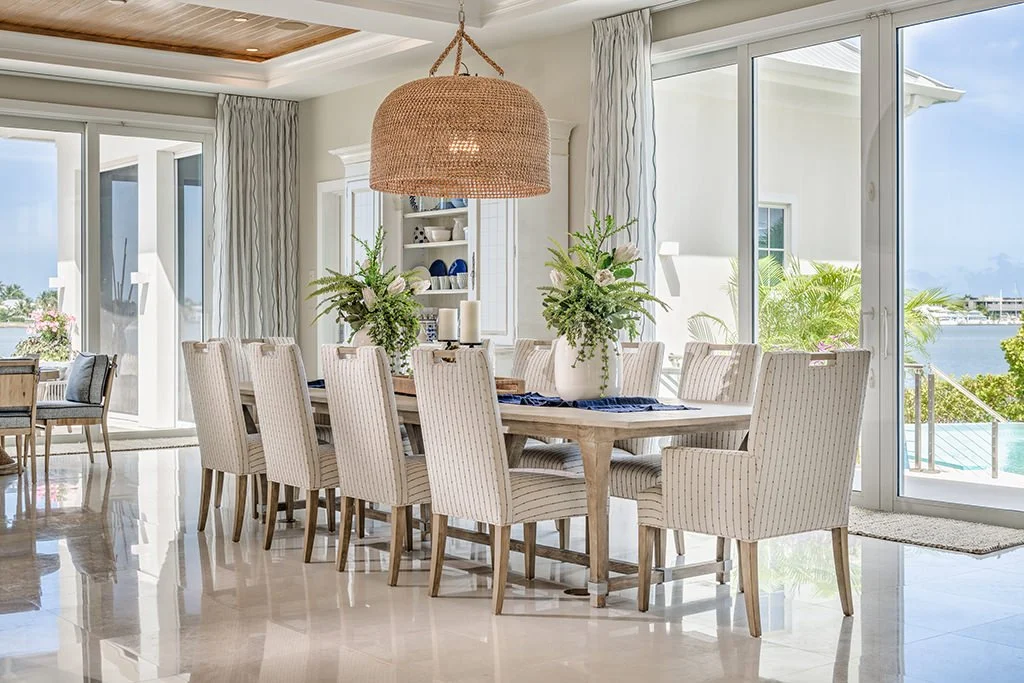 Bright coastal Palm Beach dining room with woven pendant chandelier and water view