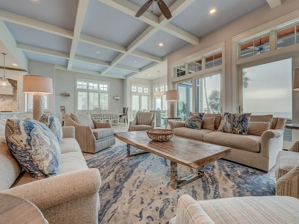 Warm neutral coastal living room in Palm Beach with blue accents and water view.