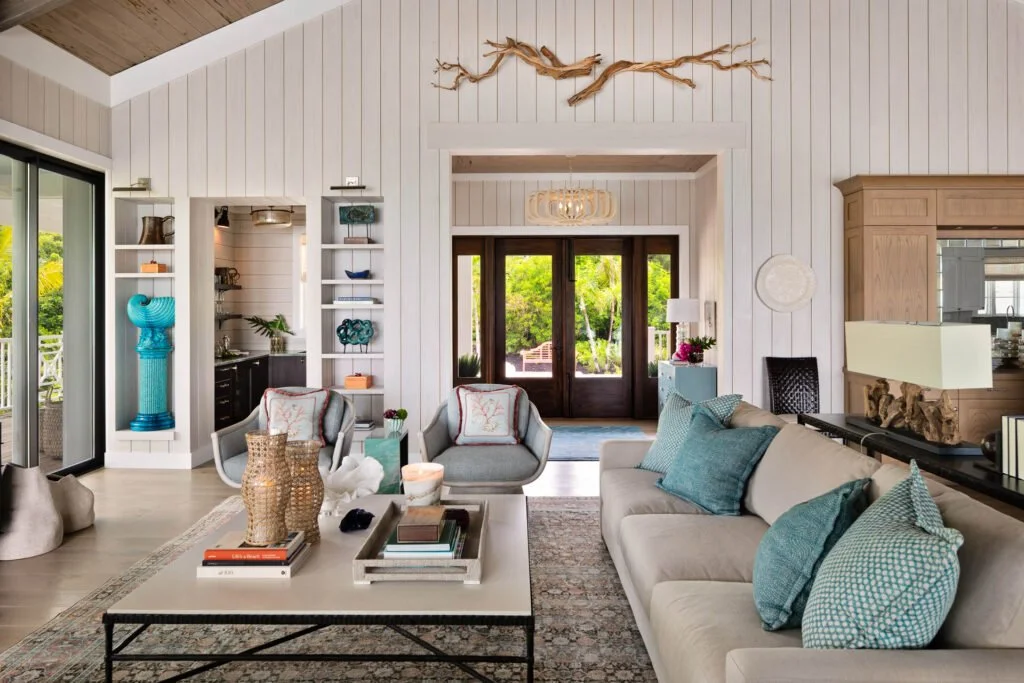 Neutral coastal living room with turquoise accents and garden view