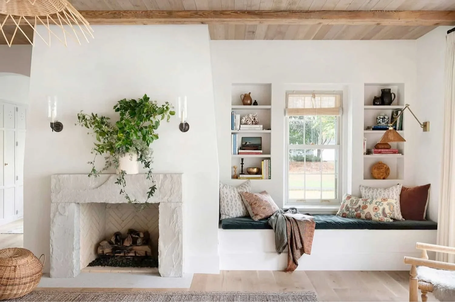 Natural light highlights aged stone, linen, and wood textures in a calm, layered sitting area.