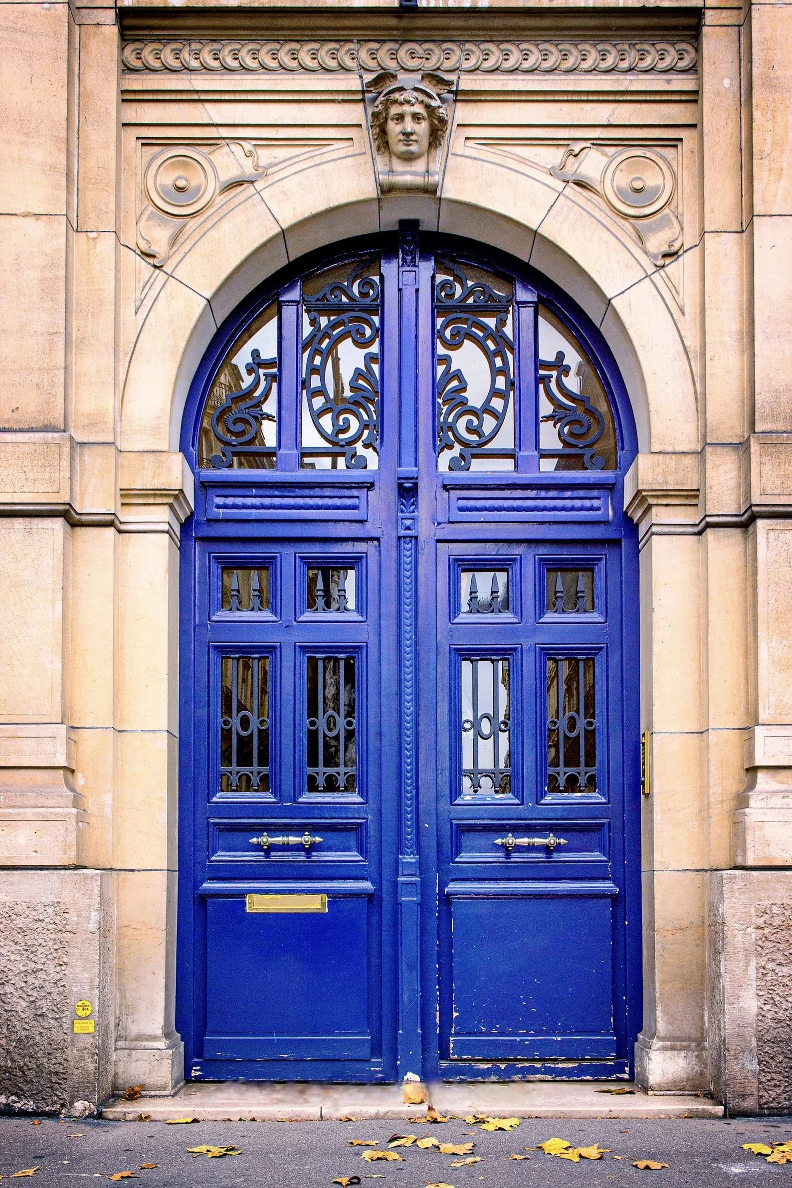 A fall day in the Marais shows vivid blue doors. and limestone creating a timeless entrance to home.