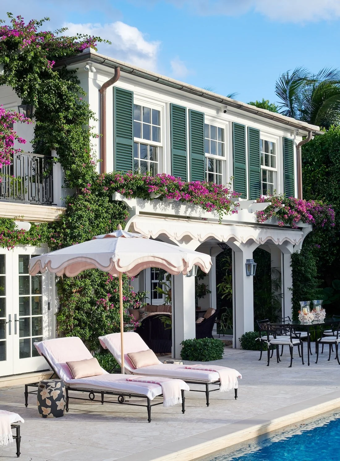 Palm Beach luxury home with poolside loungers and bougainvillea climbing the house.