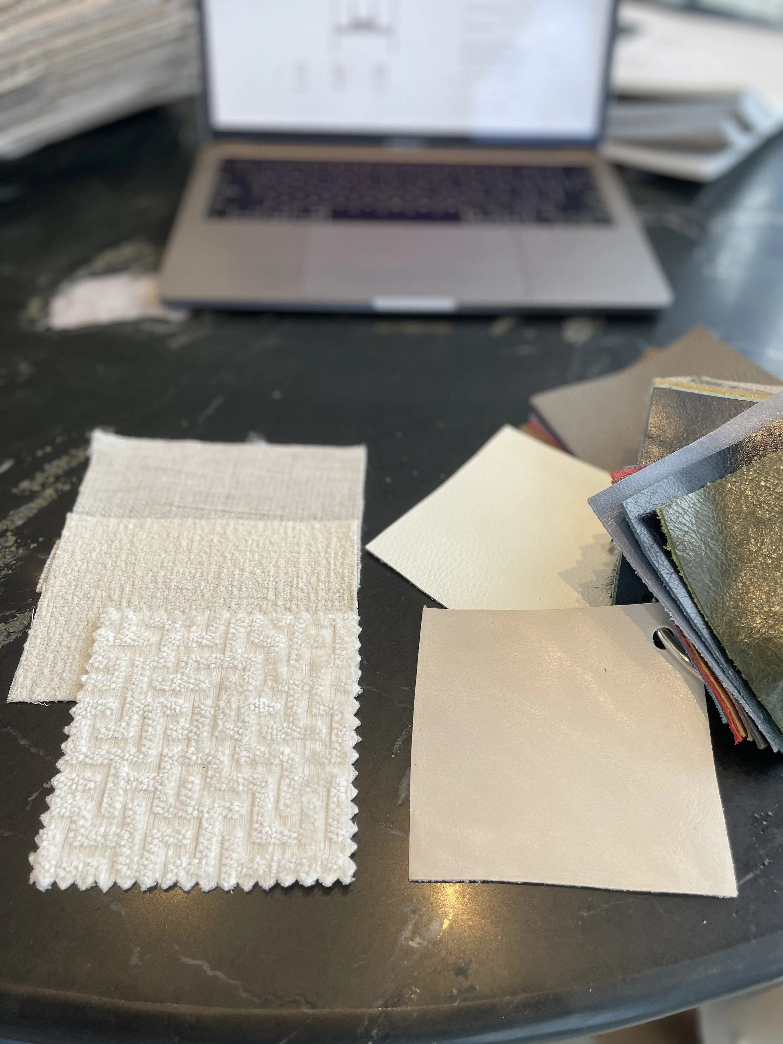 Palm Beach Full-Service Interior Design project shows a black marble desktop with fabric swatches being finalized for custom furnishings.