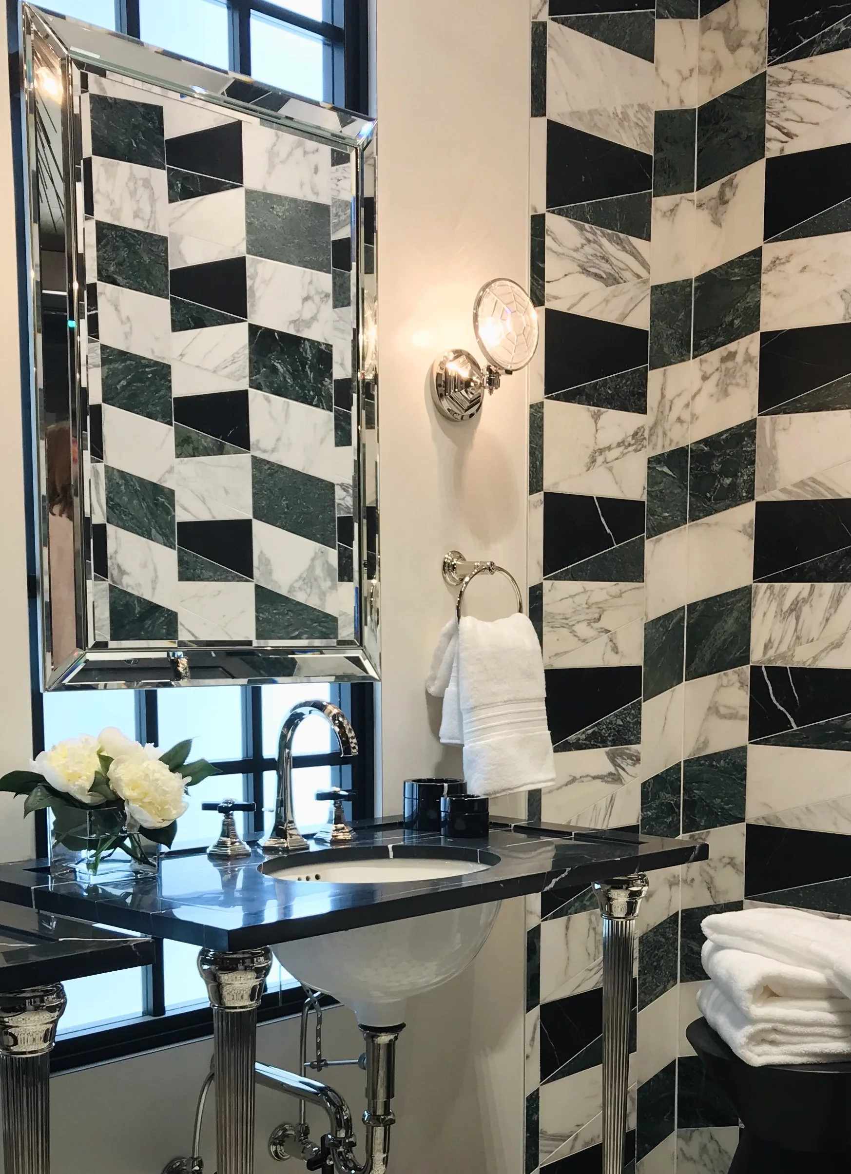This closeup of a Palm Beach luxury design bathroom shows the beauty of luxurious and timeless finishes, tile, vanity, plumbing, and lighting.