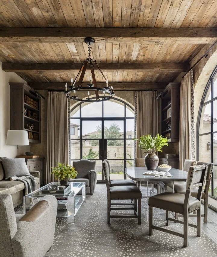 Rustic coastal Palm Beach lounge with wood ceiling and arched windows