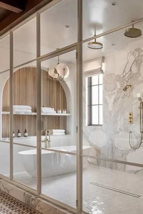 Marble luxury bathroom with arched niche, tub, and glass shower