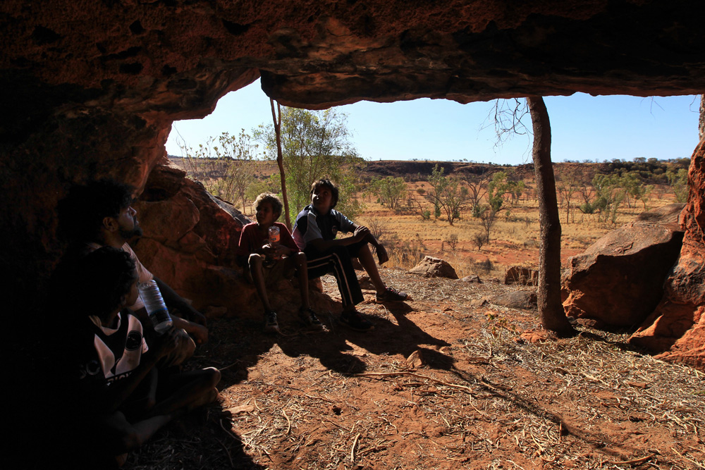  Louis and three of his students take refuge from the sun in one of the red sandstone caves that flank the edges of Kings Creek in Watarrka National Park in Australia’s Northern Territory. 