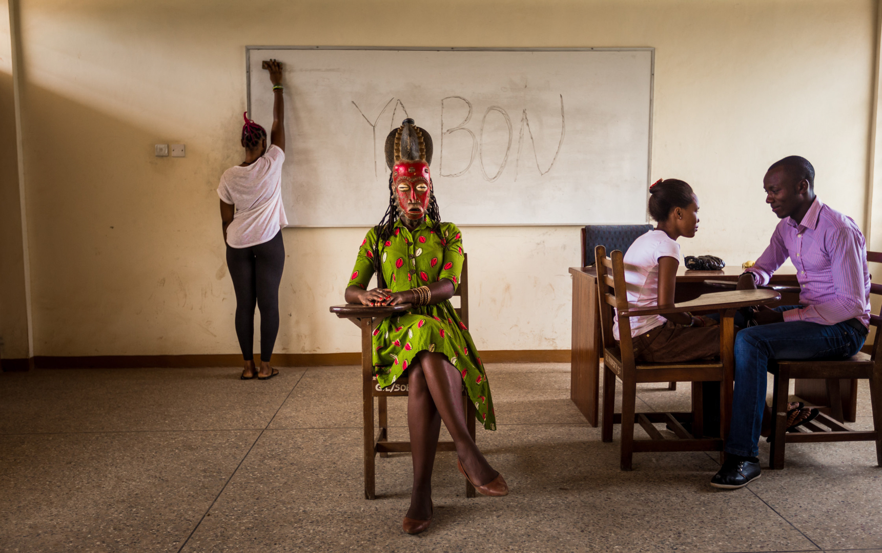  In a classroom at Accra University, Jacqueline wears a queen mask from the Baule, a people who three hundred years ago moved from what is now western Ghana to what is now central Côte d’Ivoire. 