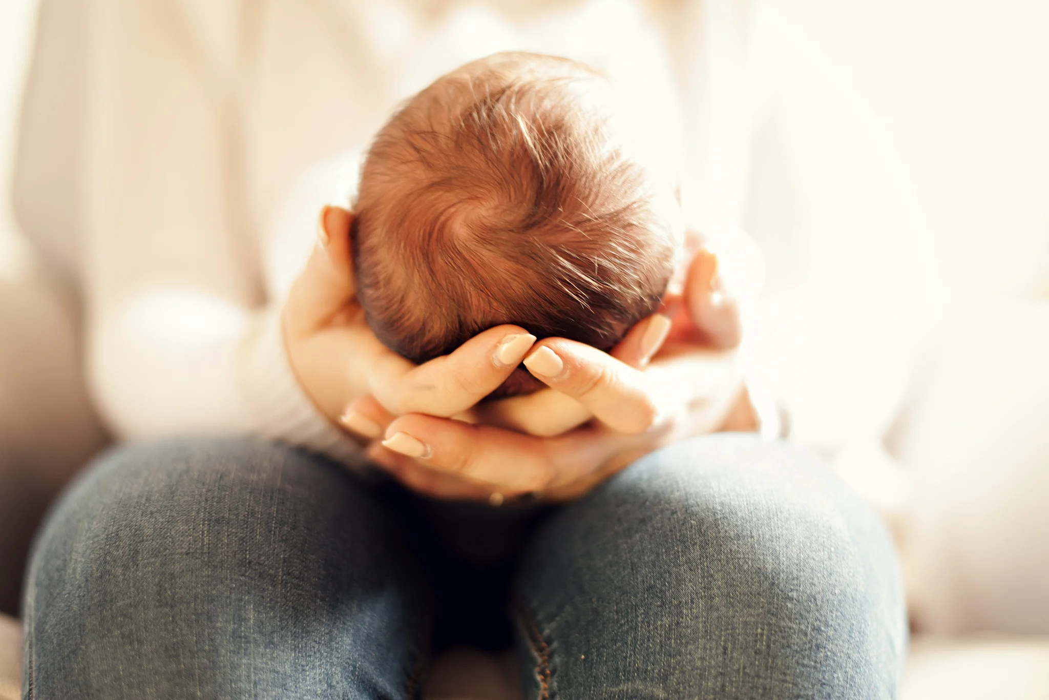 Close up of babys head in mothers hands