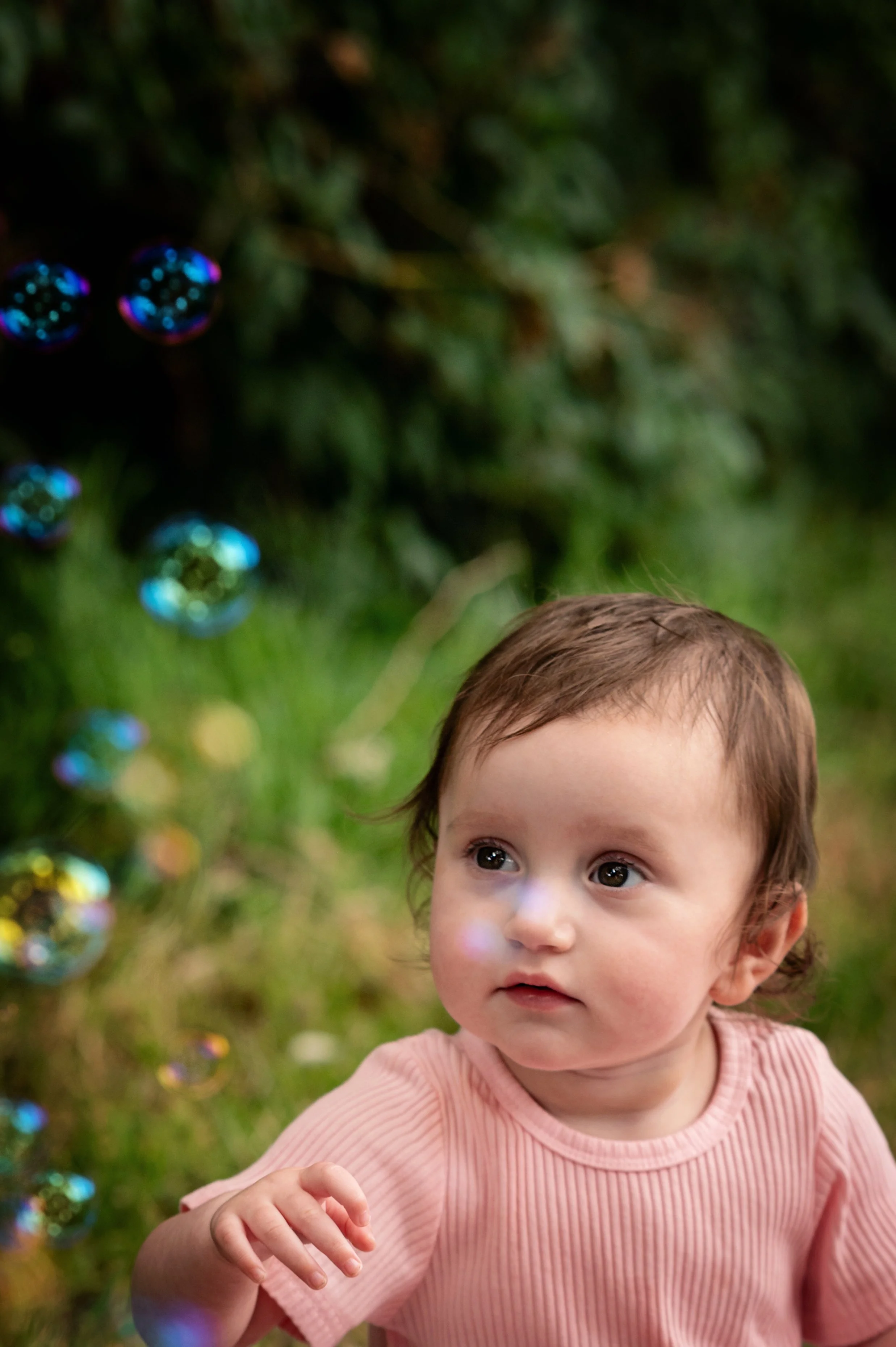 baby girl marvels at bubbles above her