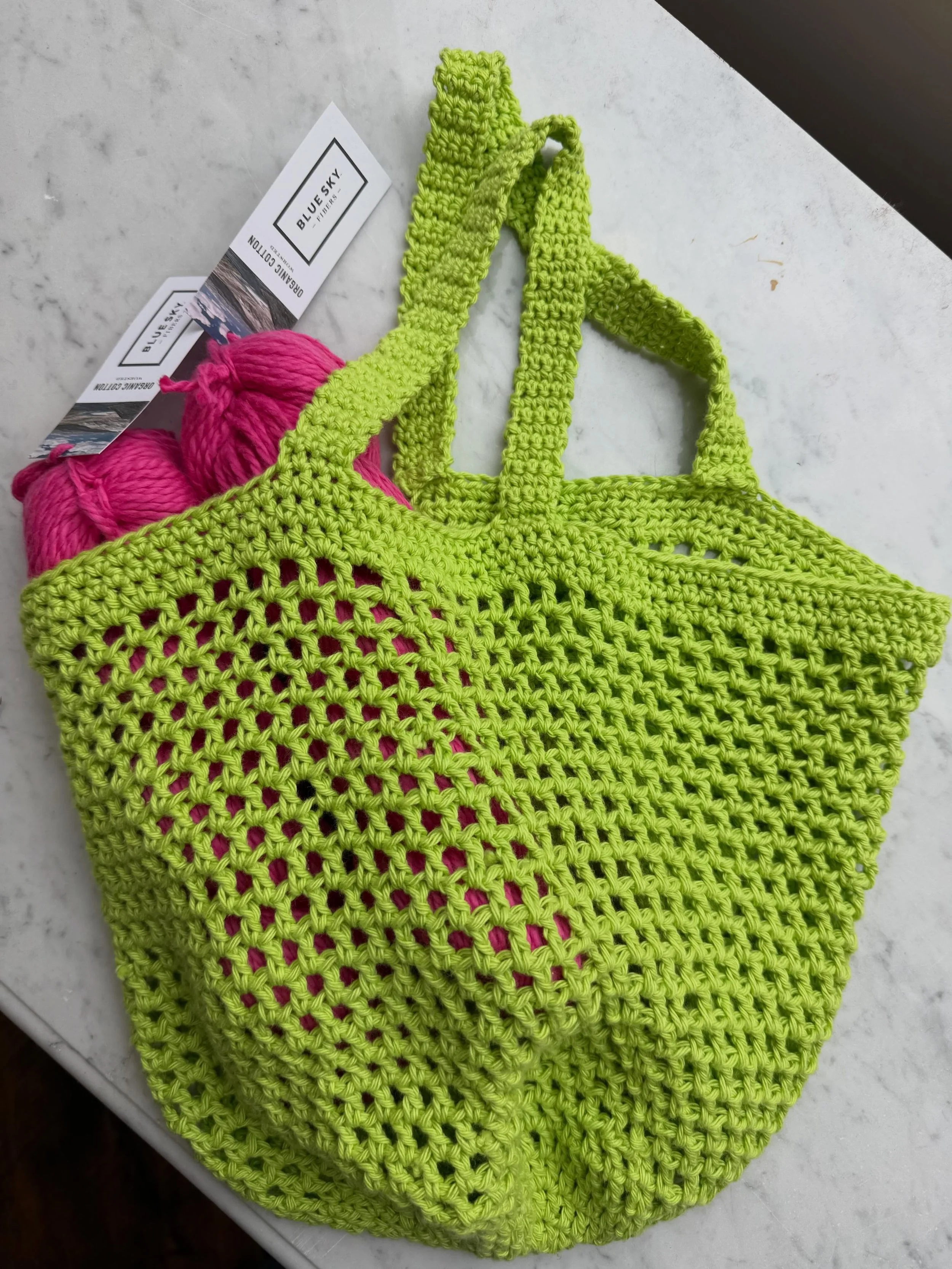 Join us to learn this super cute mesh bag.  Made with a basic worsted weight cotton yarn, these crochet bags take up very little space but then expand to hold groceries, yarn purchases or even your beach essentials!  Once you make one, you'll want to