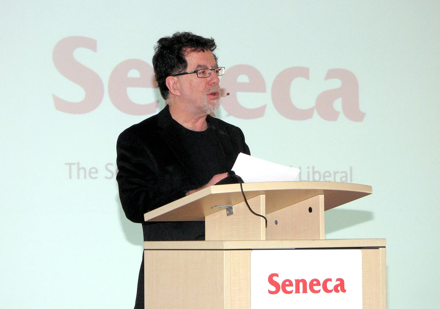 Bruce's keynote presentation: "Reading Minds, Not Lips" 2011, English and Liberal Studies Colloquium. Seneca College. (Image: A brown-haired man speaking into a headset mic from a podium against a white background that says Seneca.)
