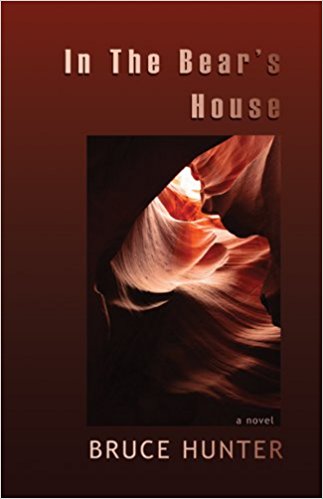 (Image: Burgundy cover of In The Bear's House with a small photograph of a sandstone cave entrance.)