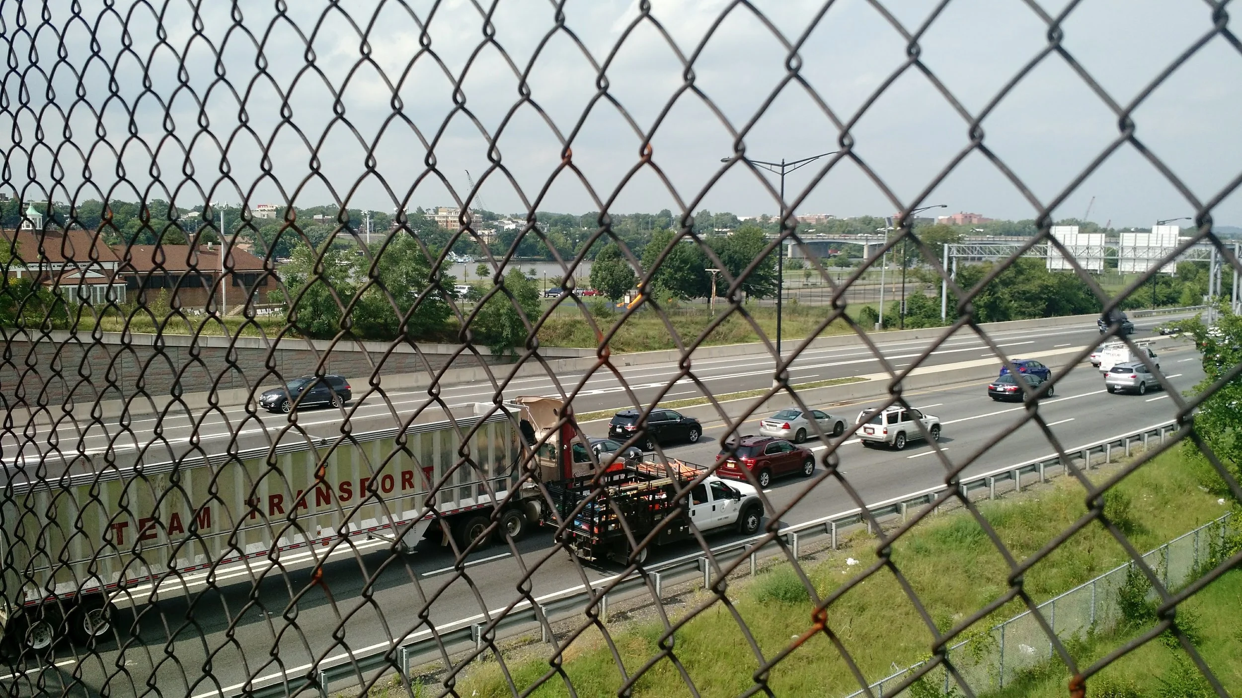 Can you spot the Anacostia River in this picture? It's there, and this photo was taken on one of the few pedestrian bridges that cross the highway to get there in Ward 8. 