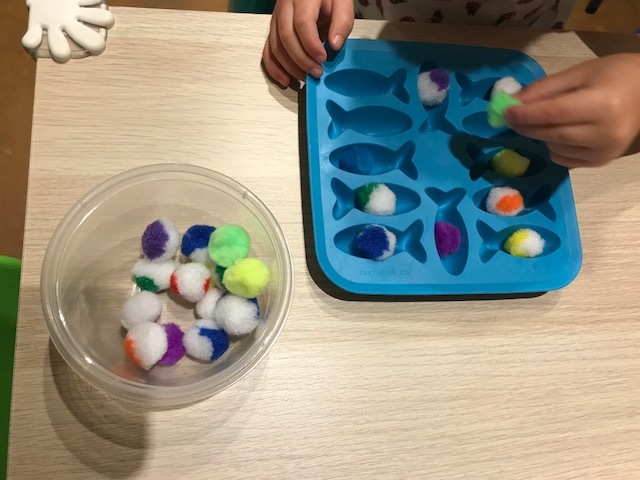 I usually put a little container with all the puffball in it to start with. It gives them a starting point and an end point. When they've got all the puffballs in the fish then they can start over and take them all out again and put them in the container. And repeat!