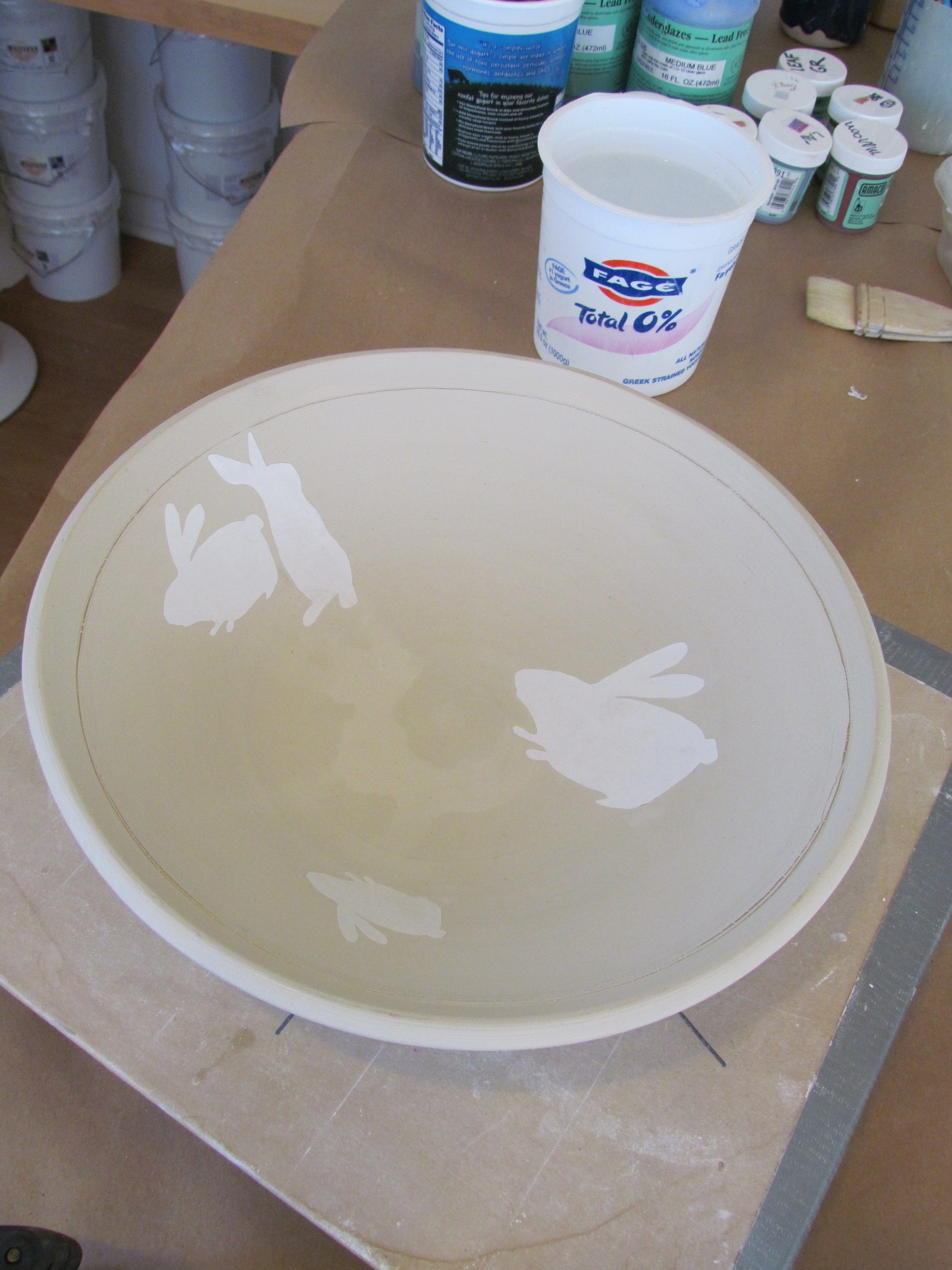 The paper stencils are arranged on the surface of a newly thrown bowl.