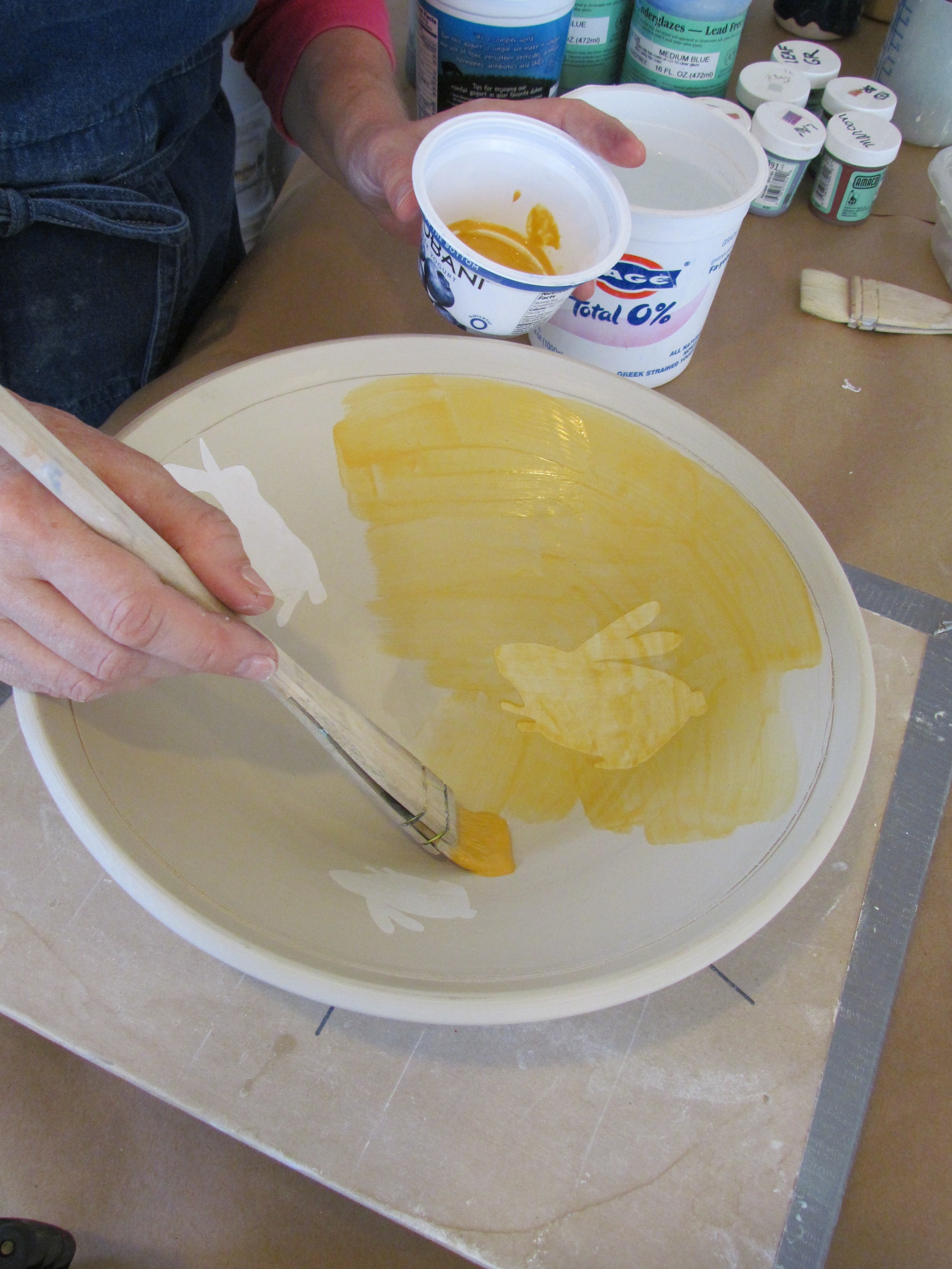The bowl is then painted with a coat of yellow underglaze.