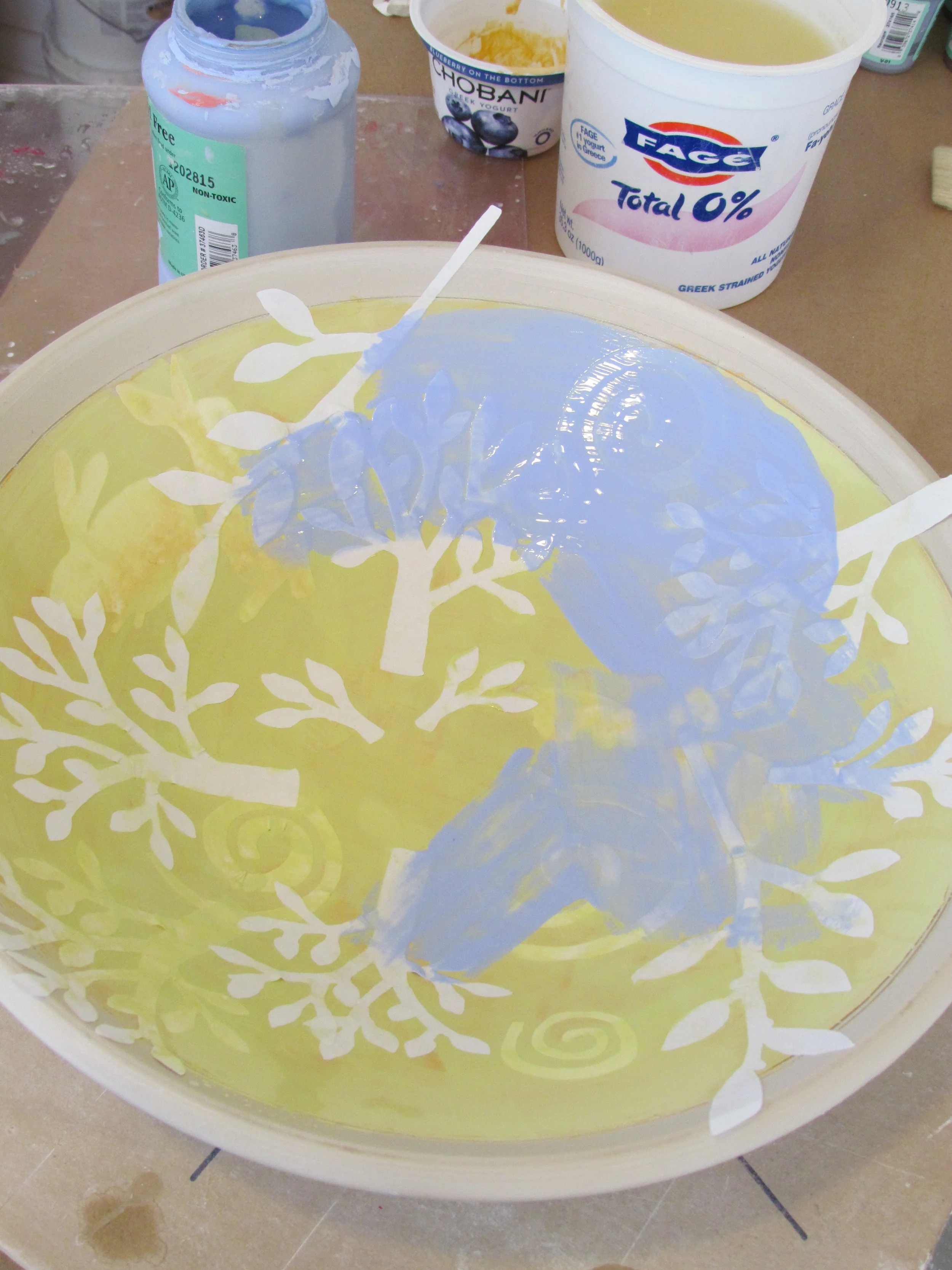 This process of layering stencils and successive layers of underglazes is repeated multiple times.