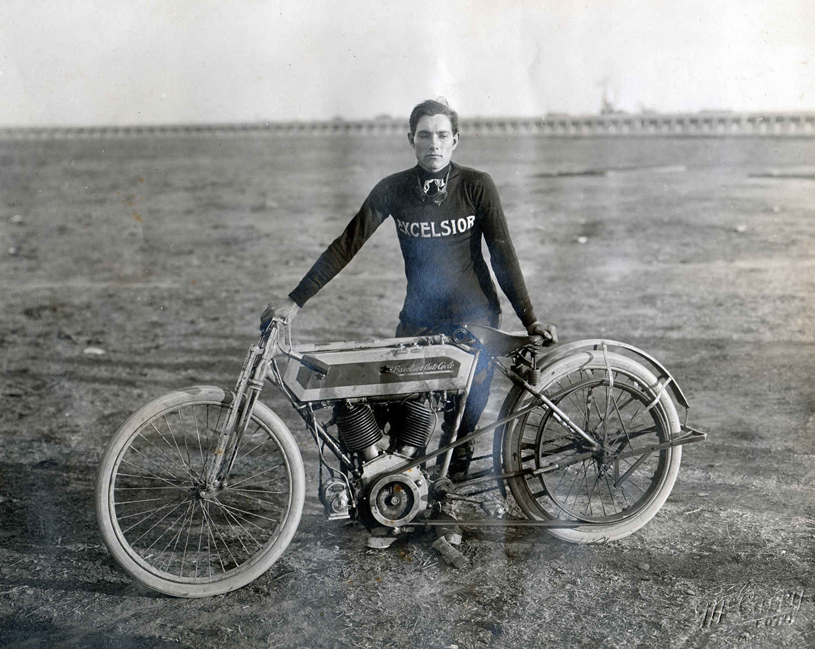 An unknown rider posing with his belt drive Excelsior at Agricultural Park in Sacramento during race week in 1912.