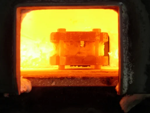 Fig. 1: Billet in the forge: note the small observation window in the coating on this billet. Color and other changes in the metal can be seen here.