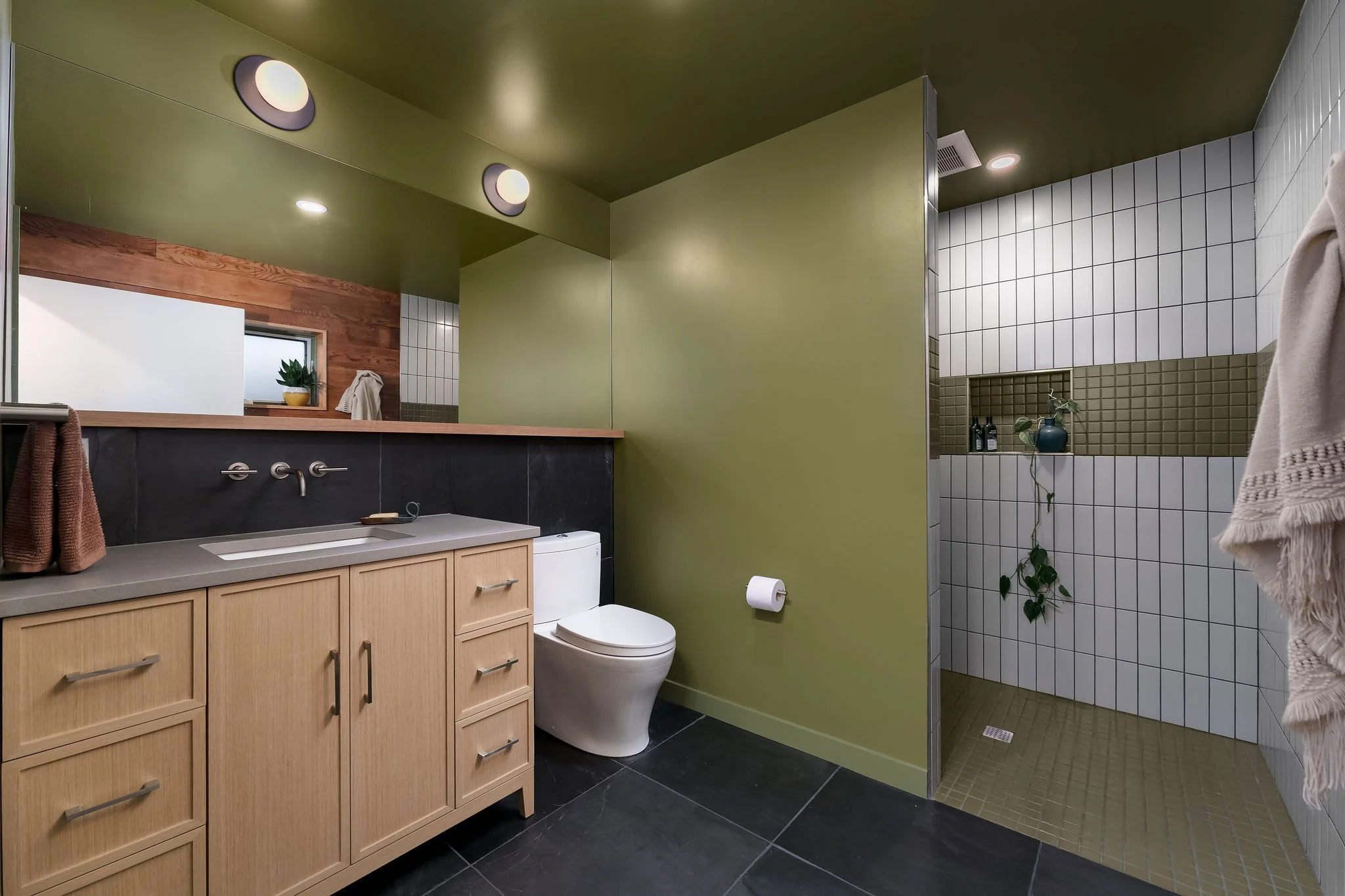 New ADU bathroom with a curbless shower and earth toned accents