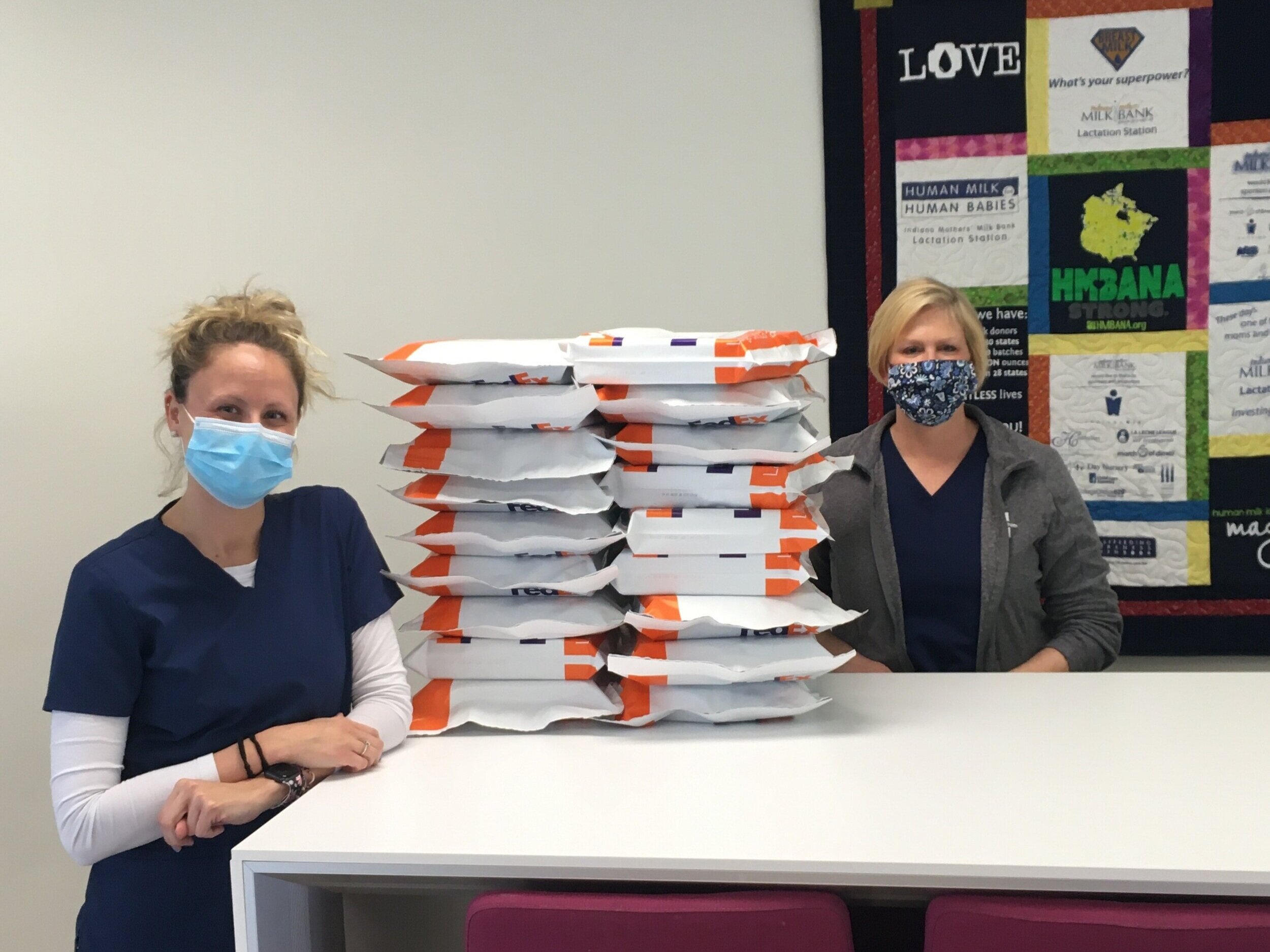 Heather &amp; Becky standing next to the tower of completed blood testing kits, ready to be sent overnight to the lab!