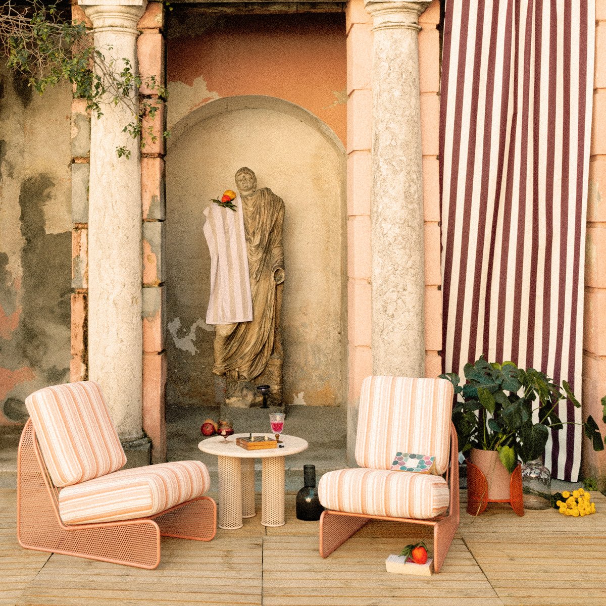 A luxury outdoor terrace featuring a full Riviera Collection set with sofas, armchairs, and marble tables against a classical villa backdrop.