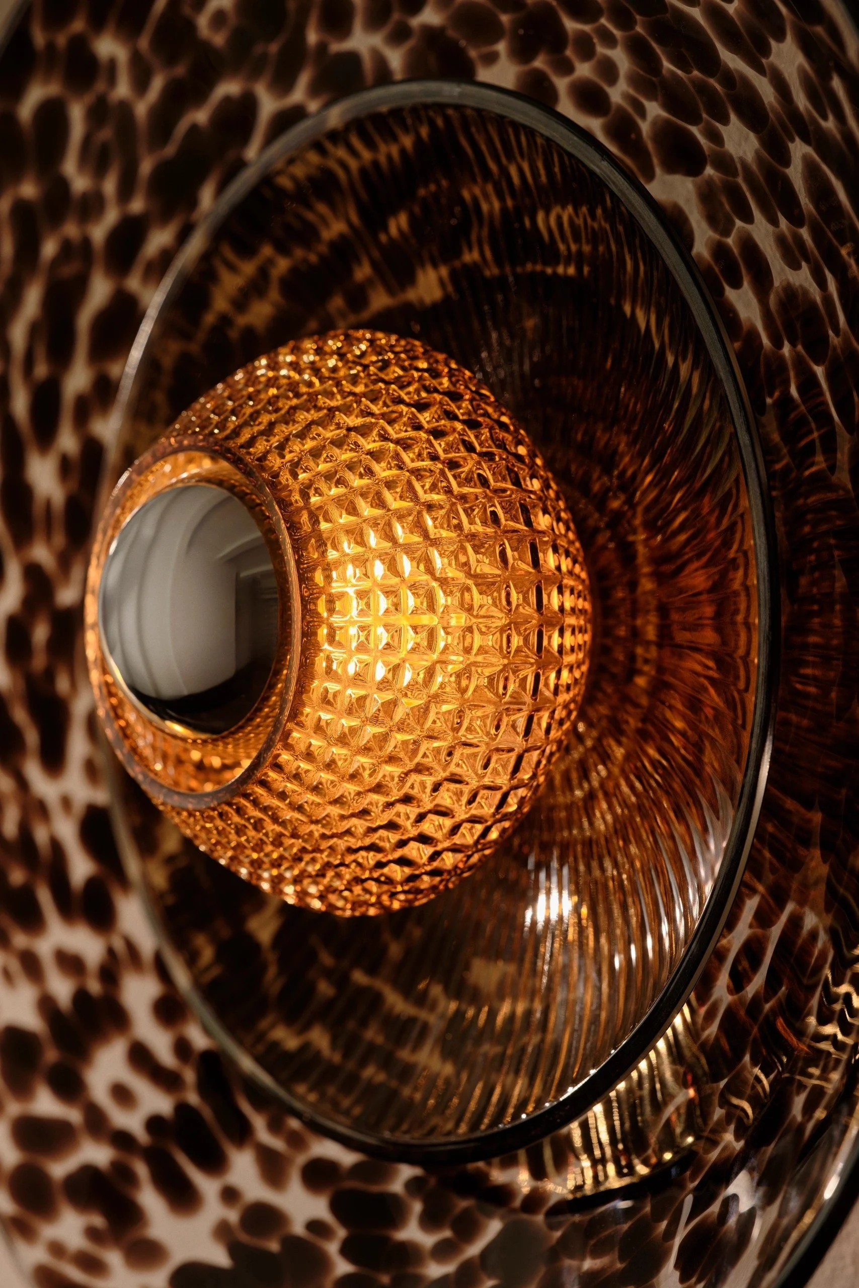 Macro detail of the Brown Disco Rama sconce's textured inner Discoball glass and mouth-blown speckling.