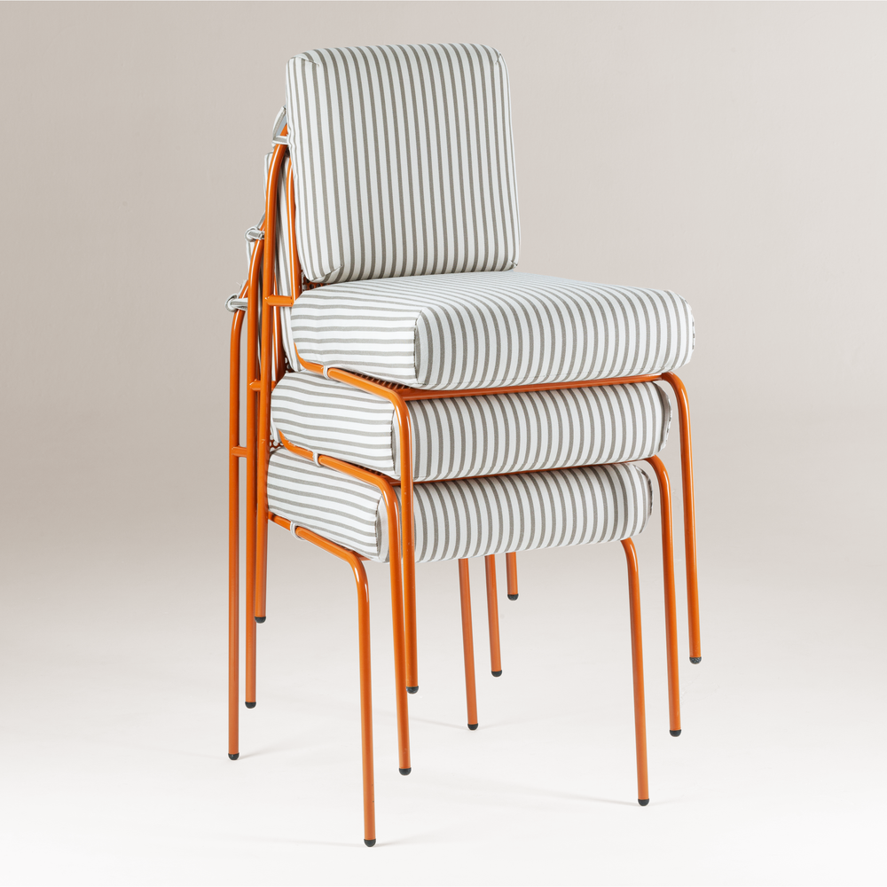 A studio shot of three striped Riviera chairs stacked neatly, demonstrating their space-saving design against a neutral off-white background.