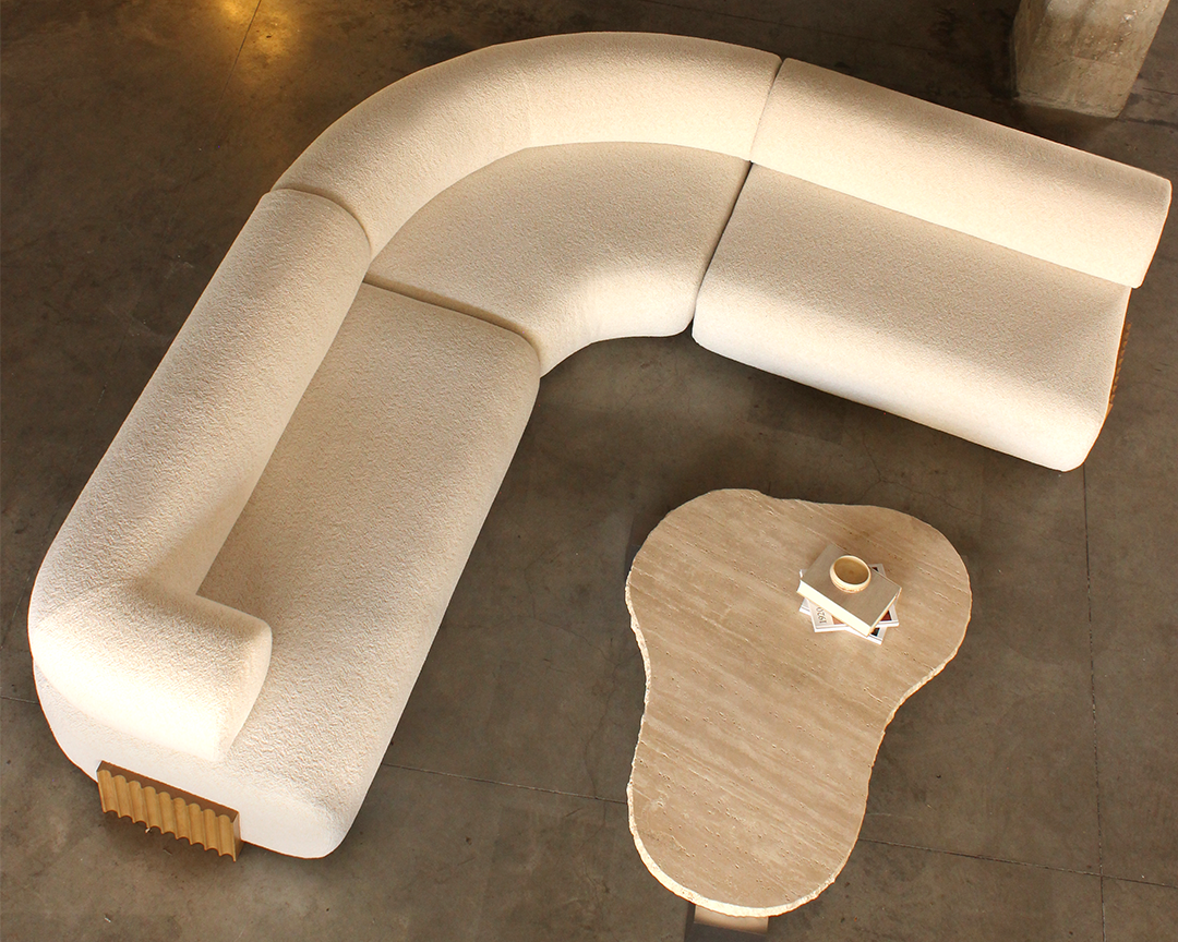 Global+Chic+interior+design+featuring+a+curved+Carmel+sofa+paired+with+textured+layered+rugs+and+architectural+forms.marie+Burgos+Collection.png.webp