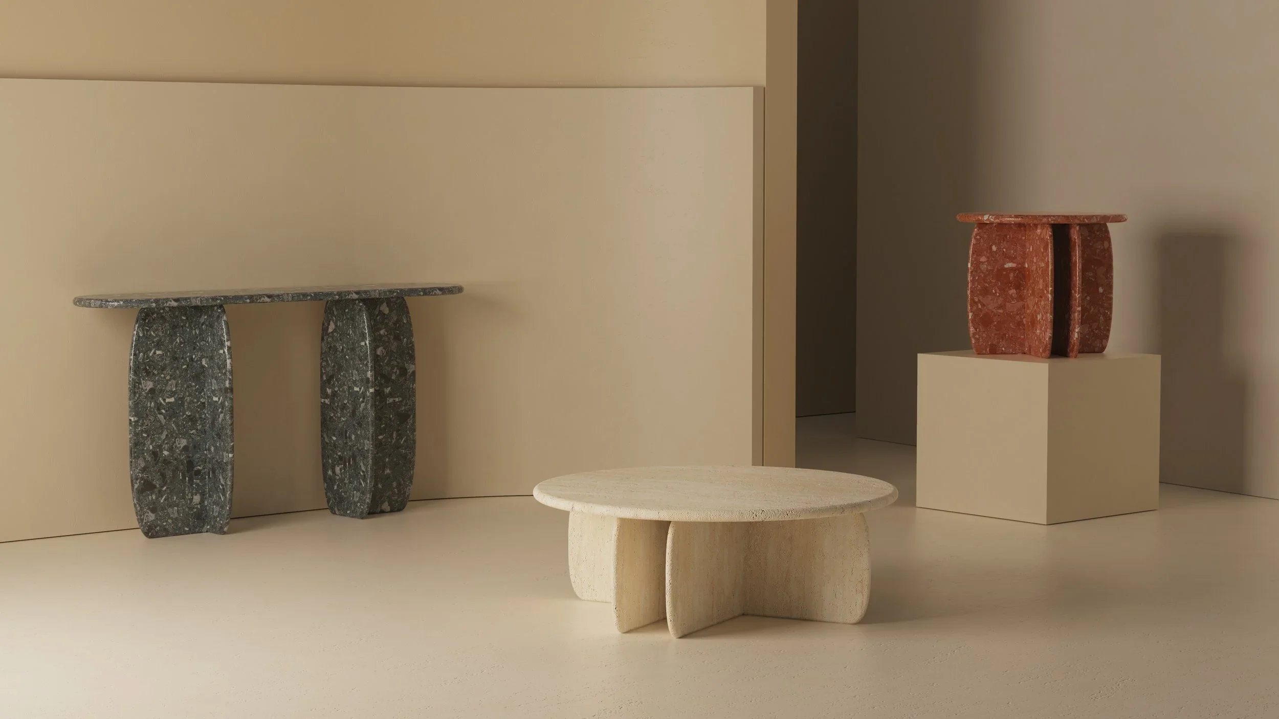 Multiple sculptural tables shown together in neutral gallery-like setting