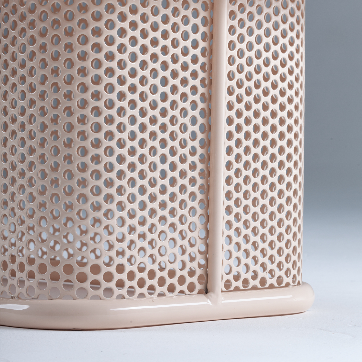 Perforated metal base detail in soft pink finish showing circular pattern on Riviera coffee table