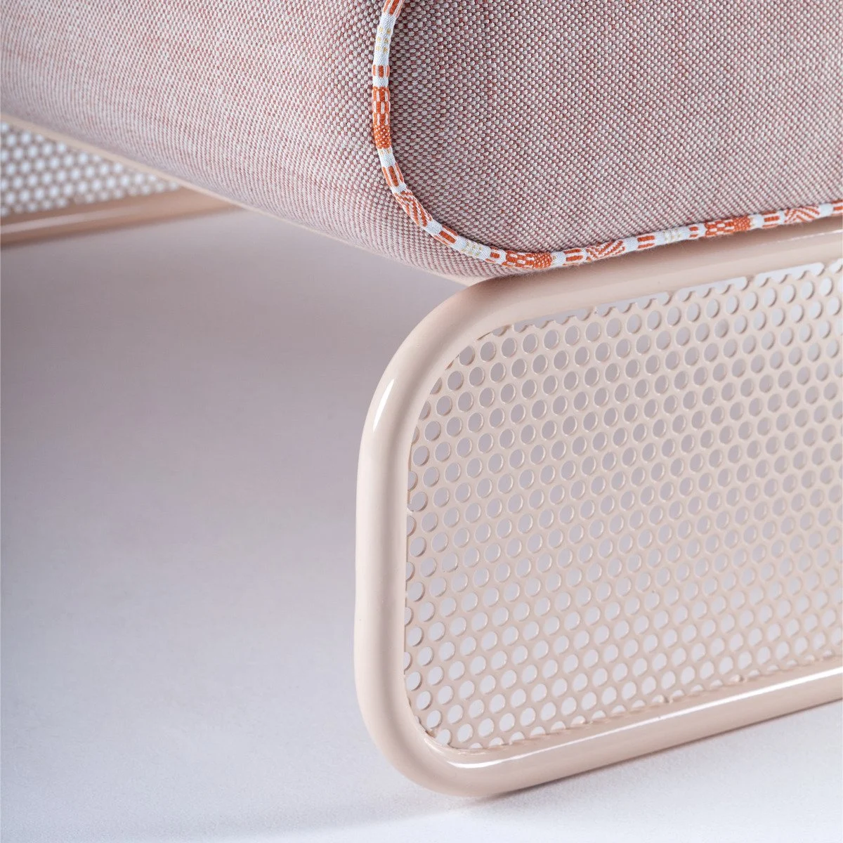 Detail of the Riviera collection's rounded, cream-lacquered perforated metal base, showcasing the seamless craftsmanship of the Marie Burgos Collection.