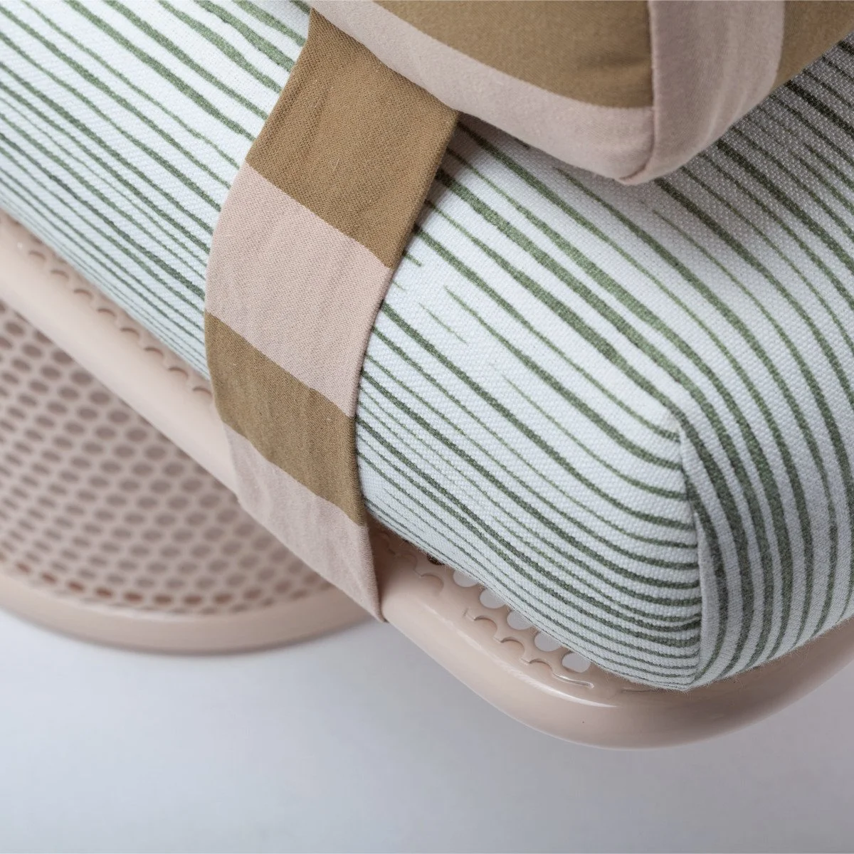 A macro shot focusing on the high-quality outdoor fabric upholstery, showing the red and white striped pattern and the neat tailoring of the bench cushion.