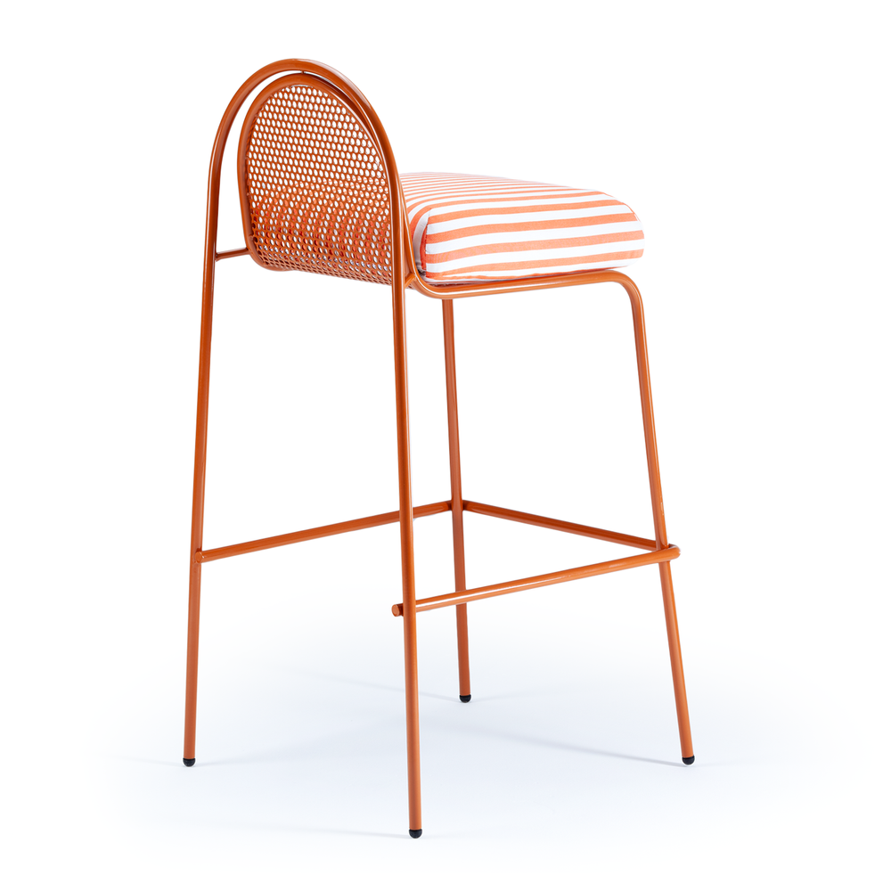 A clean studio shot of an orange metal bar chair viewed from the rear three-quarter angle, highlighting the perforated semi-circle backrest and striped cushion.