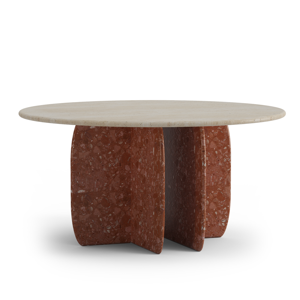 Round dining table with sculptural base in red stone finish, combining bold materiality with modern outdoor design.
