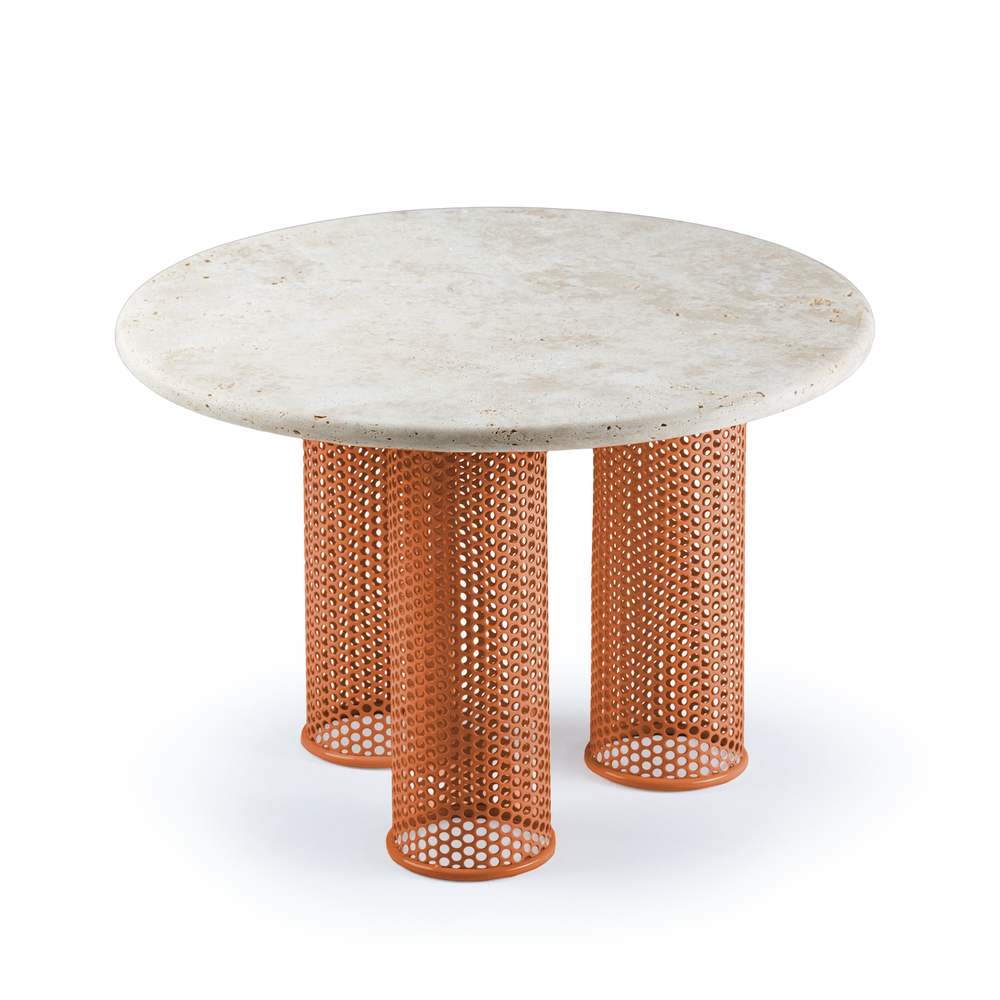 Contemporary side table featuring a travertine top and bold orange perforated base for a playful yet refined design.