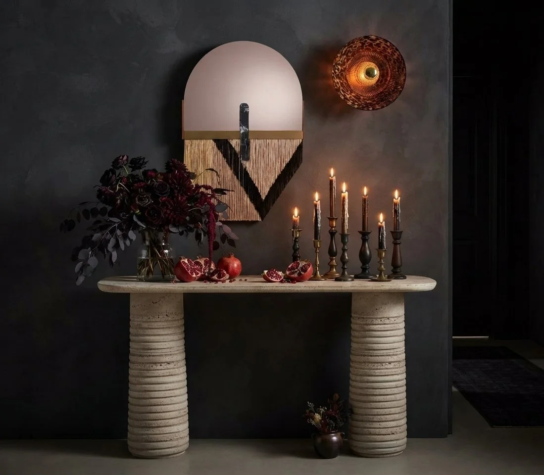 Entrance console tables n travertine marble flanked bytan iconic mirror and light sconce
