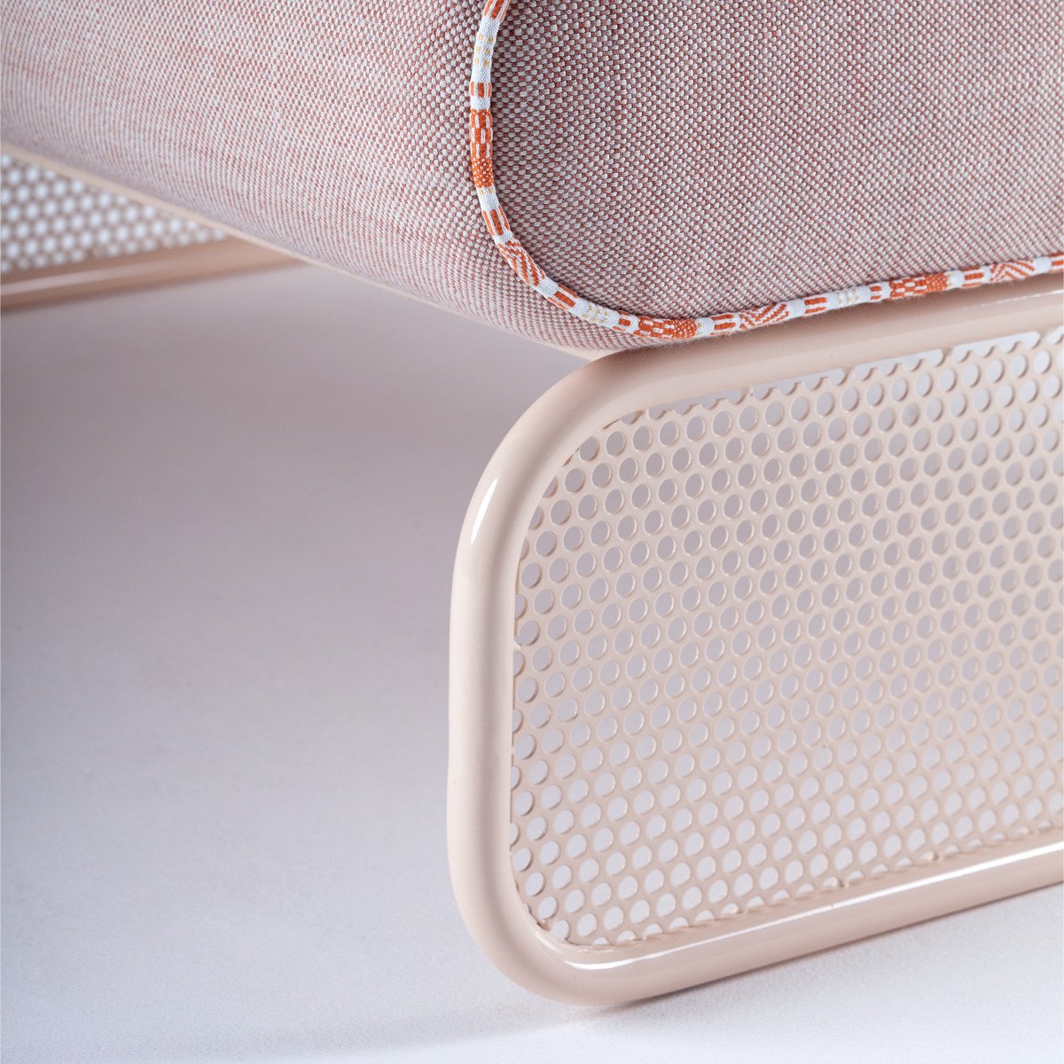 Detail of the Riviera collection's rounded, cream-lacquered perforated metal base, showcasing the seamless craftsmanship of the Marie Burgos Collection.