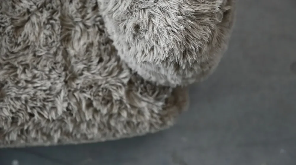 Close-up detail of the plush feather-filled cushion and premium fabric texture on the Saba chair.