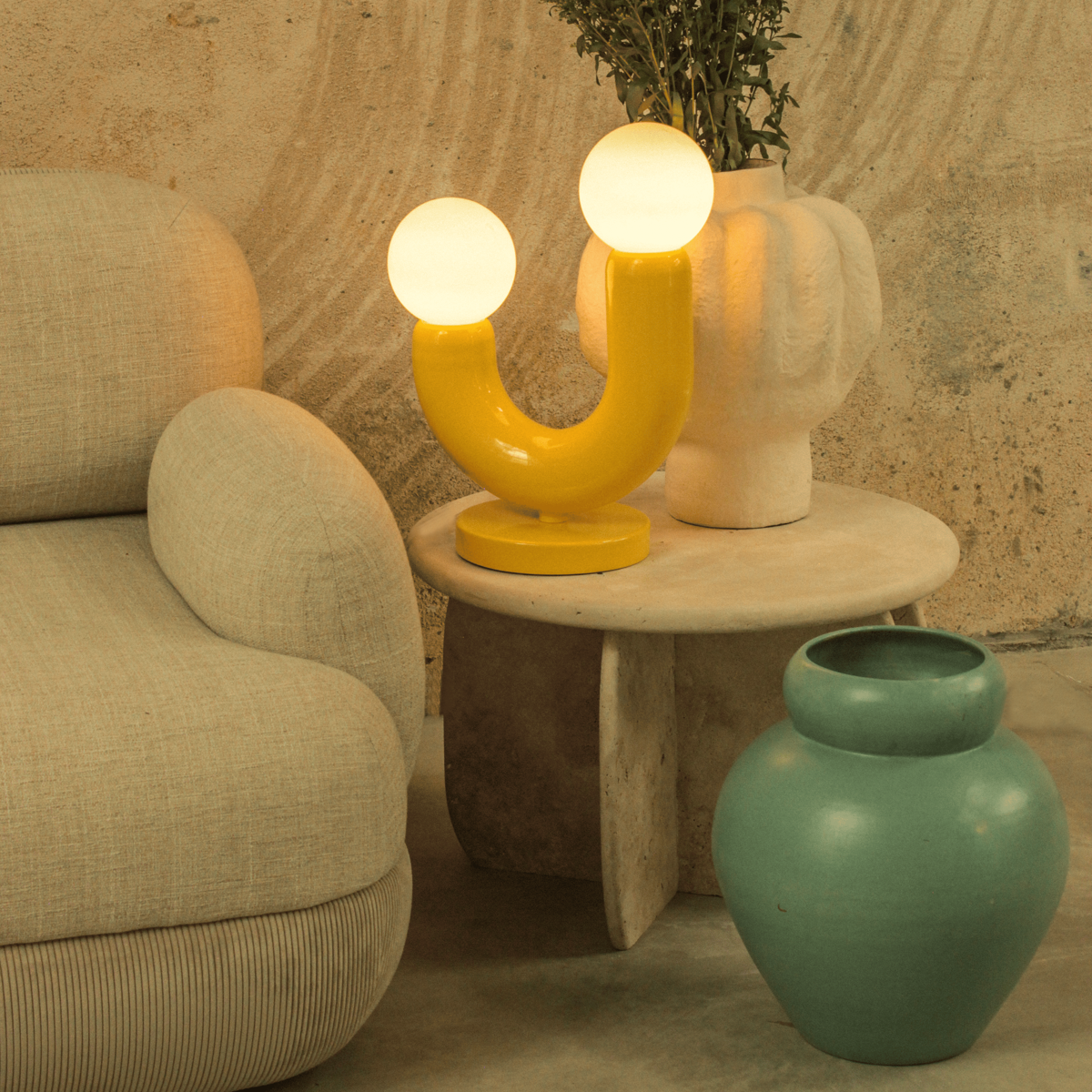 Styled scene with sculptural side table, decorative lighting and modern decor