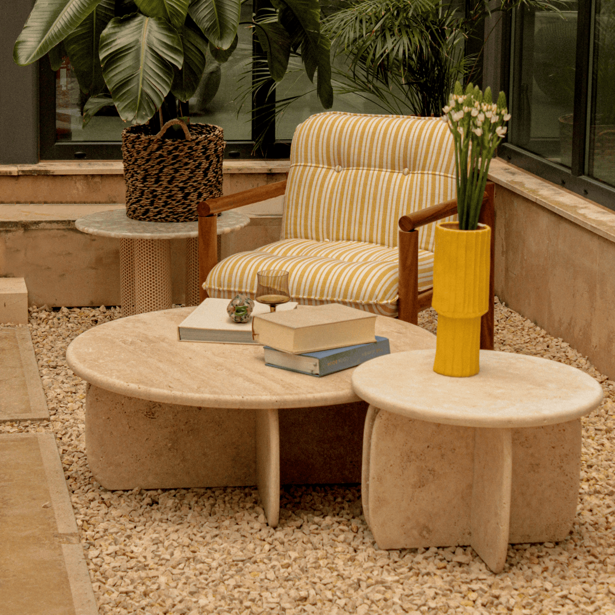 Travertine table placed in outdoor patio with plants and warm tones