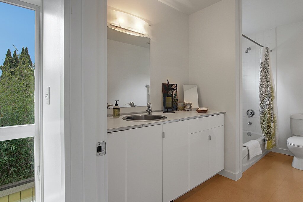  The full bathroom has a large vanity with lots of storage and matching cabinets to the kitchen. 