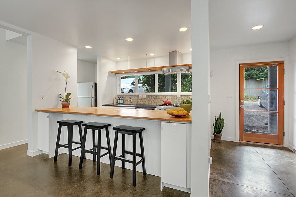  The open kitchen has a large wooden island counter with abundant storage. 